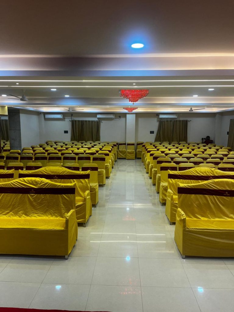 A corporate event venue at Raaj Hotel set up with neat rows of chairs for a presentation.