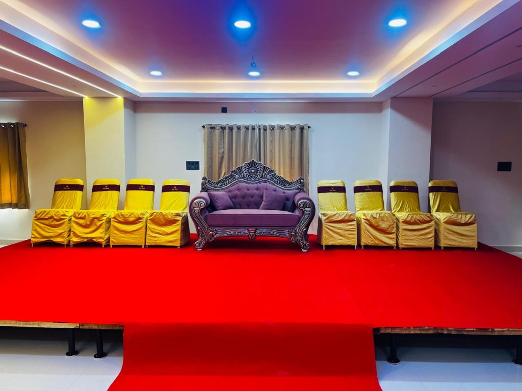 The main stage area in a Raaj Hotel function hall, ready for a presentation or performance.