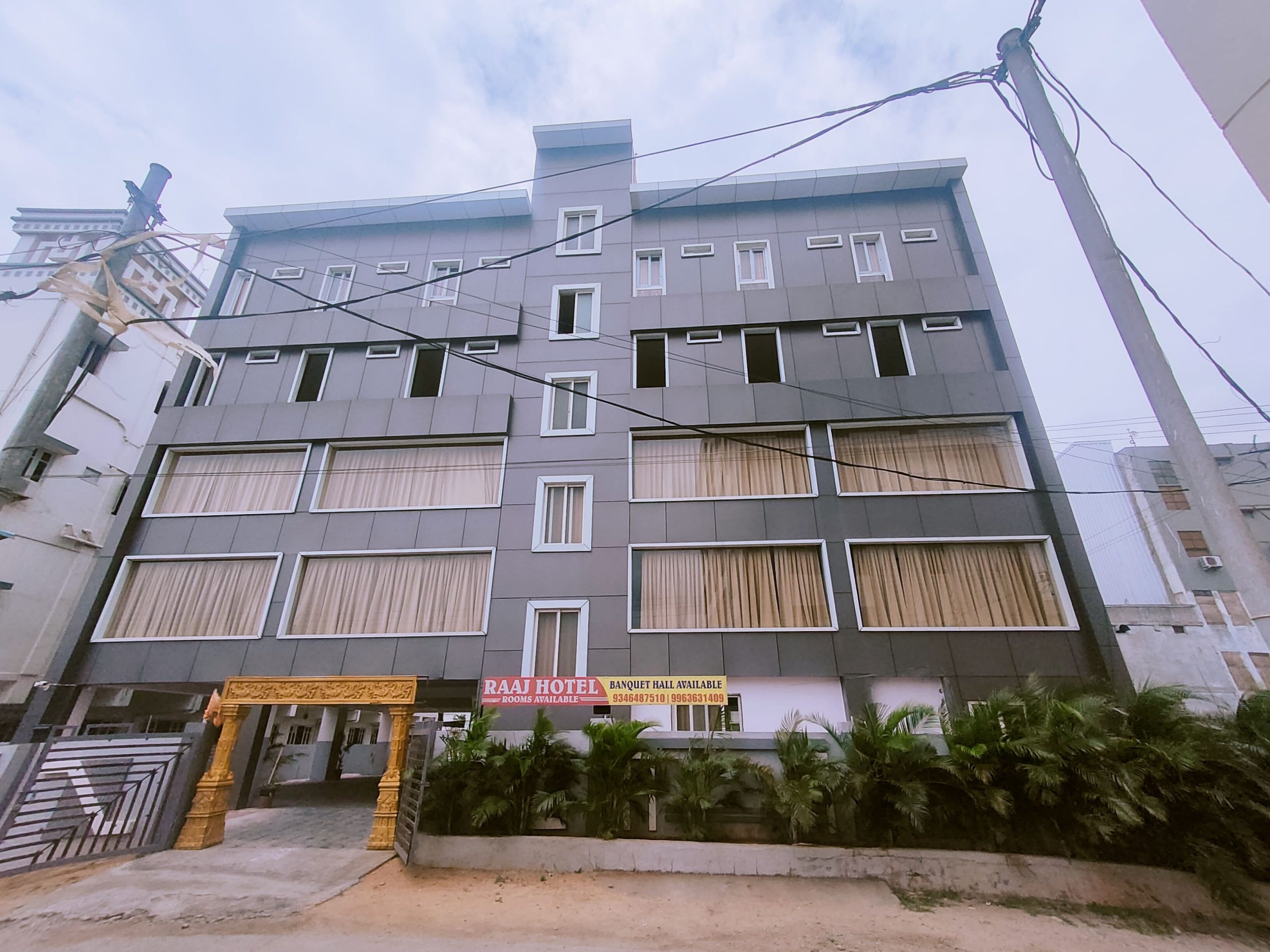 The modern facade of the Raaj Hotel in Mallapur, showcasing the exterior design of the 24-room hotel and event space near Noma Function Hall.